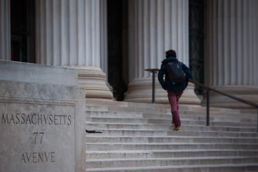 rear view of person walking up the steps to the entrance of MIT building 7
